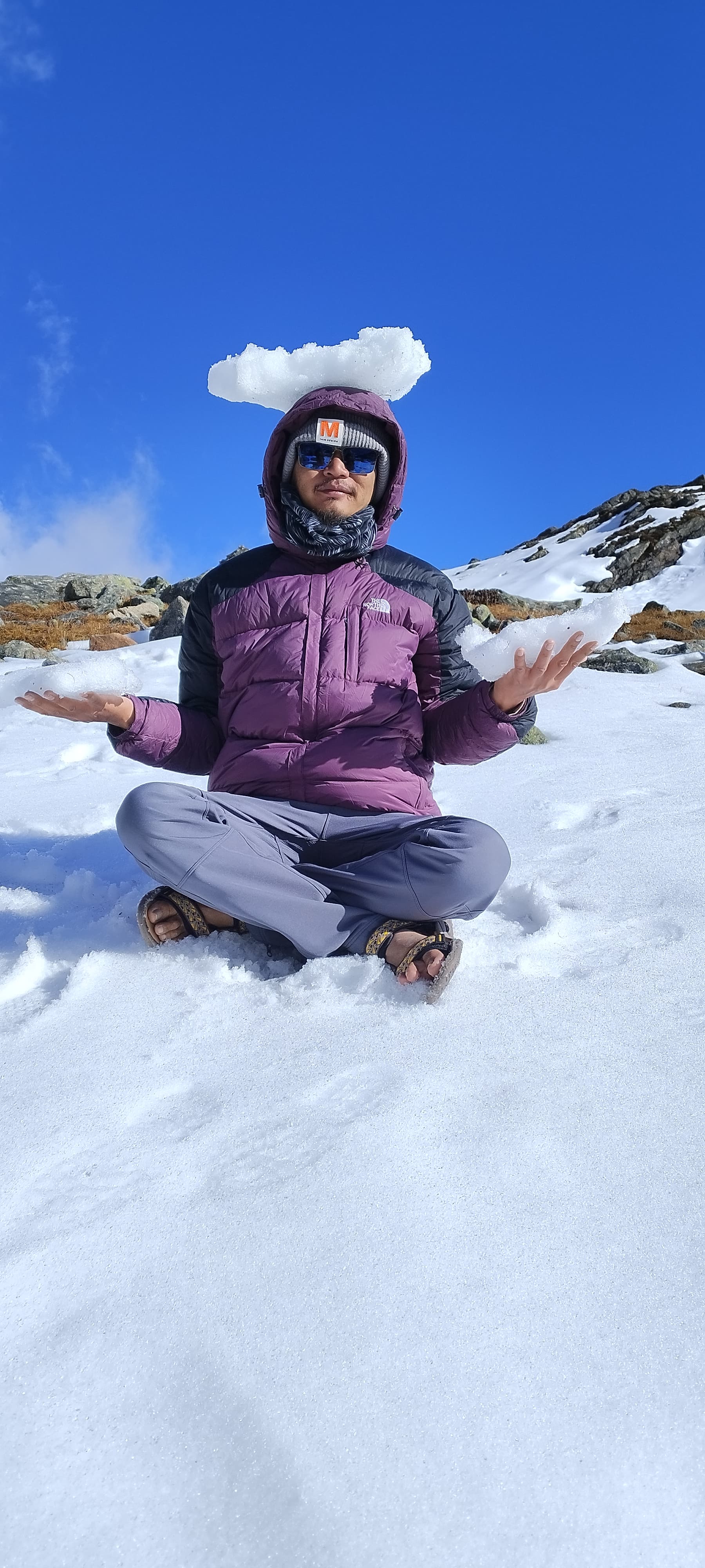 Meditating in lotus posture in Himalayan snow during a high-altitude yoga retreat